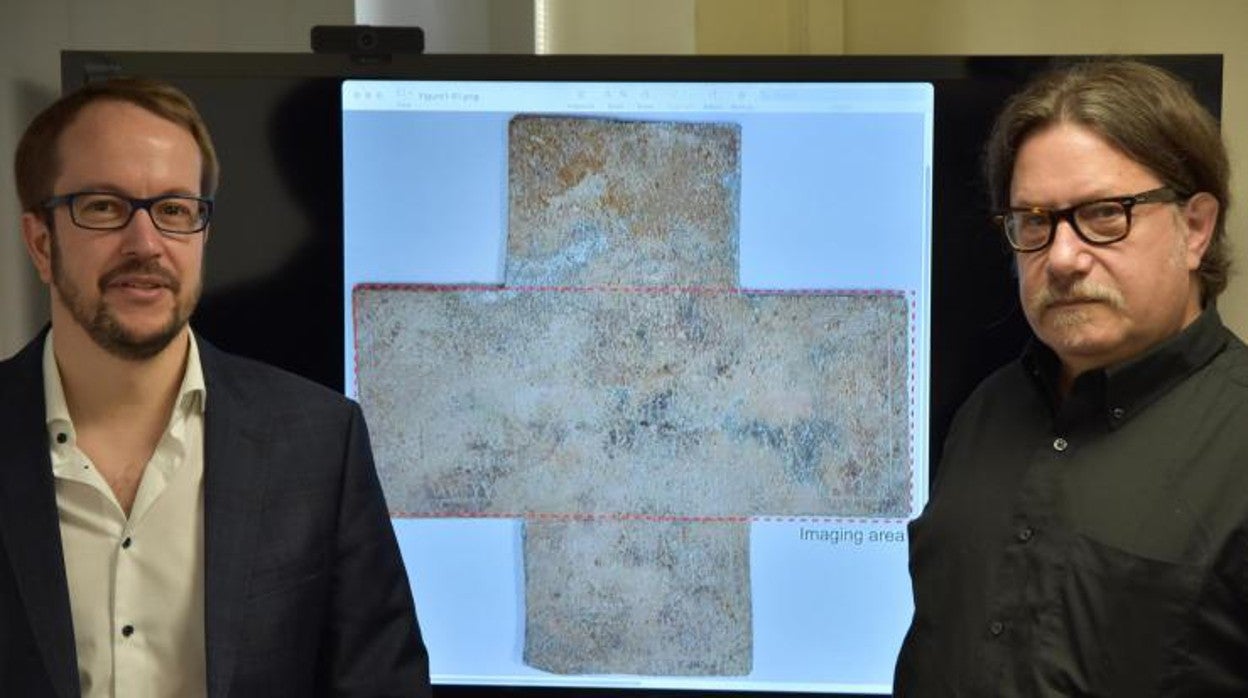 El profesor de Georgia Tech David Citrin (derecha) y el profesor adjunto Alexandre Locquet ante una imagen de la cruz funeraria del siglo XVI que han estudiado