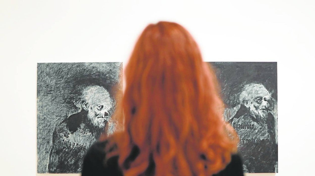 Una visitante observa dos de los retratos de Ezra Pound sobre papel