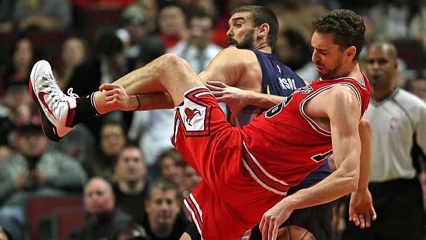 Pau y Marc Gasol luchan por un balón durante el partido