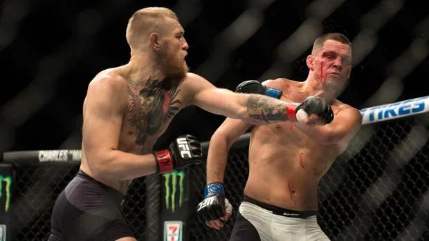 El irlandés Conor McGregor (izq.) golpea a Nate Díaz (dcha.) durante el UFC 202