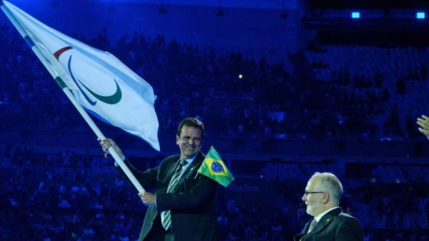 El alcalde de Río de Janeiro, Eduardo Paes, sujeta la bandera olímpica durante la ceremonia