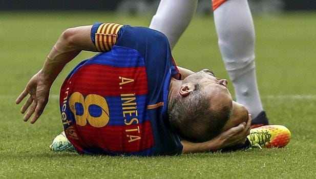 Andrés Iniesta se duele en el suelo durante un partido disputado con el Barcelona