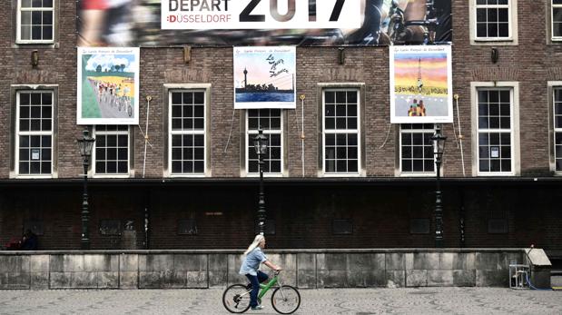 Una ciclista bajo el cartel del Tour en Düsseldorf.