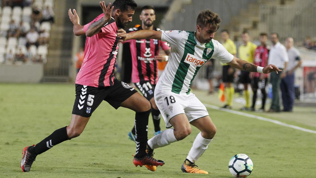 El central del Córdoba CF Josema conduce el balón ante el tinerfeñista Alberto