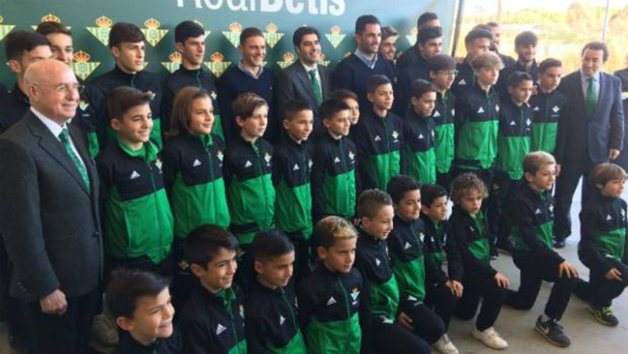 Ángel Haro y Joaquín, en el centro, posan con niños de la cantera en la comida de Navidad del Betis