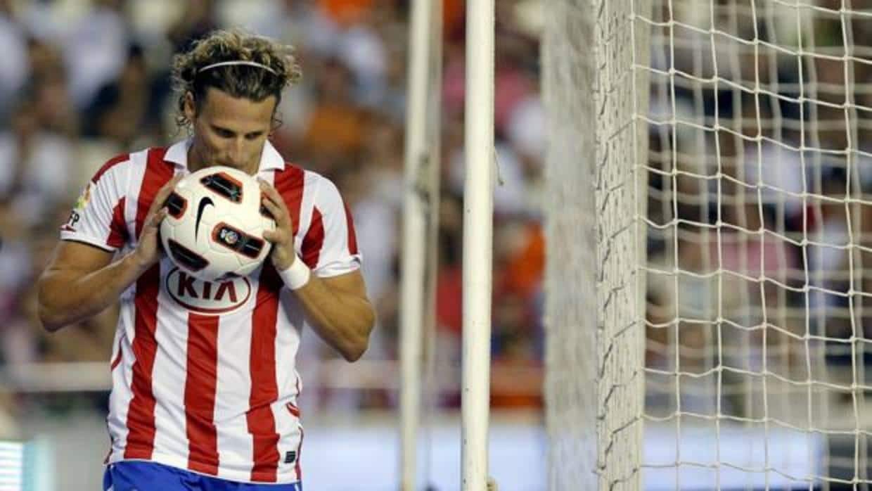 Diego Forlán besa un balón cuando jugaba en el Atlético de Madrid.