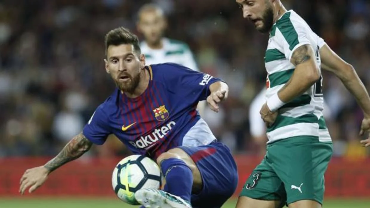 Leo Messi y David Junca pelean un balón
