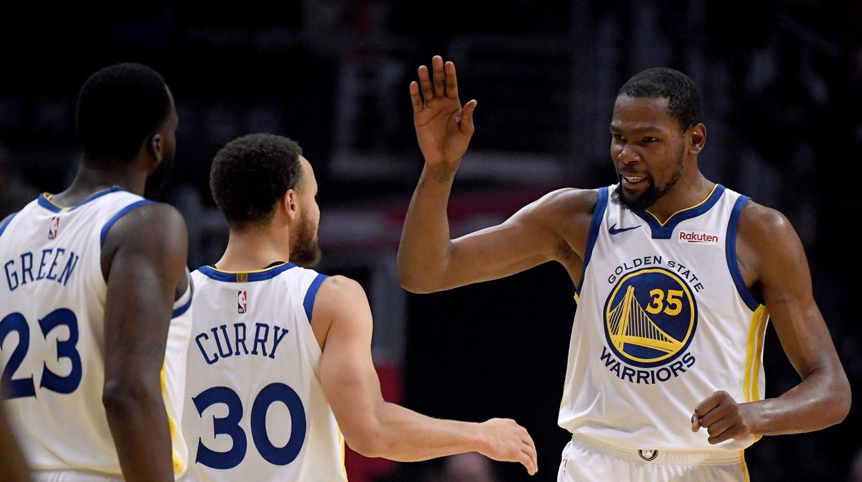 Kevin Durant celebra el triunfo con sus compañeros Curry y Green