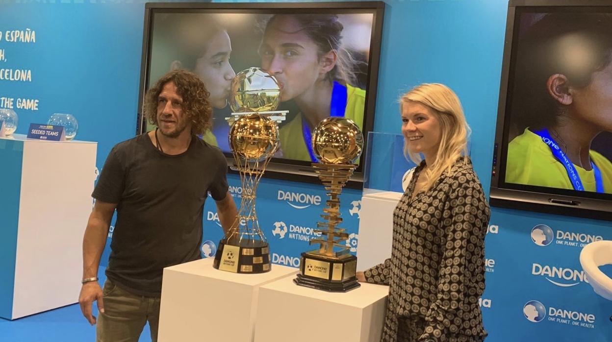 Carles Puyol y Ada Hegerberg con los trofeos de la Danone Nations Cup