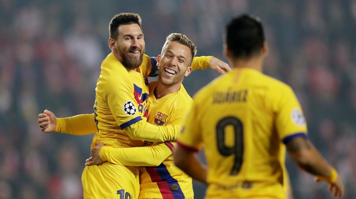 Messi y Arthur se abrazan ante la mirada de Luis Suárez