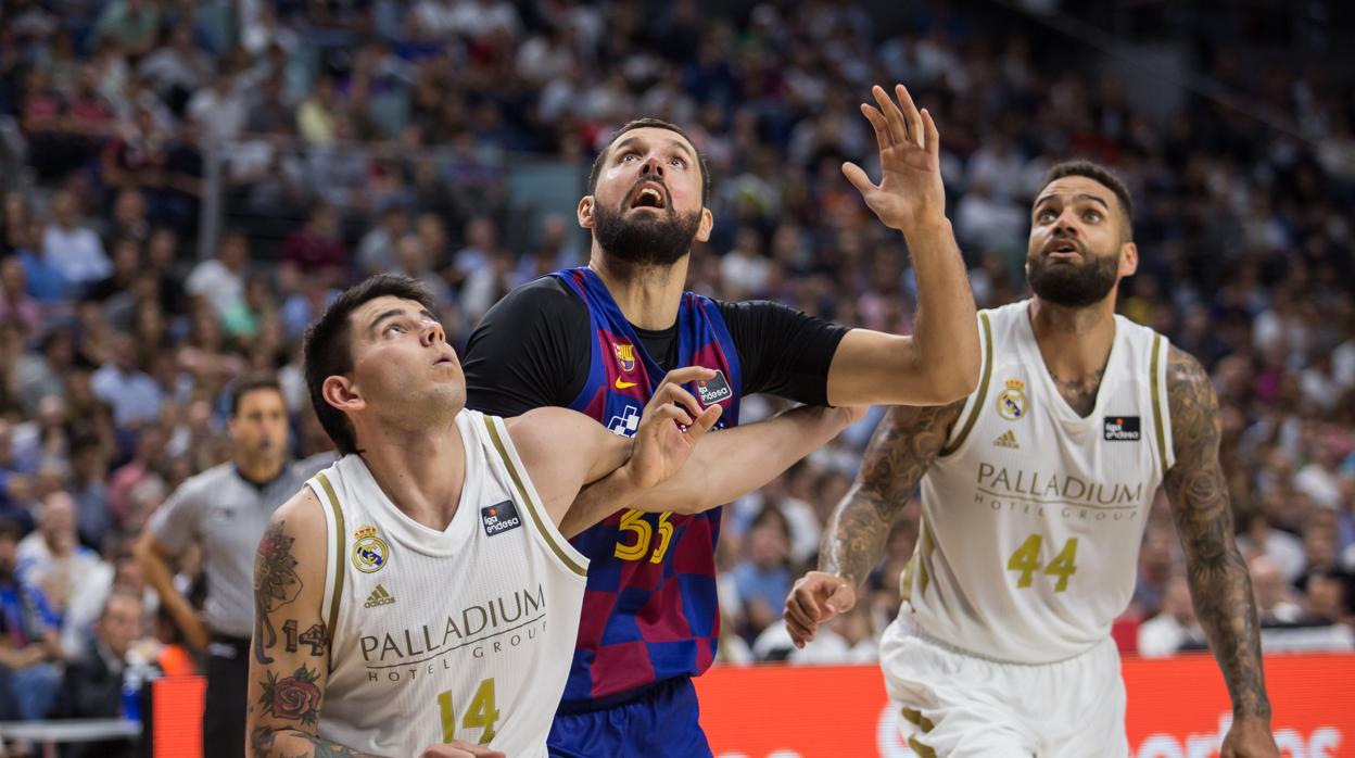 Mirotic pelea un rebote con Deck ante la mirada de Taylor