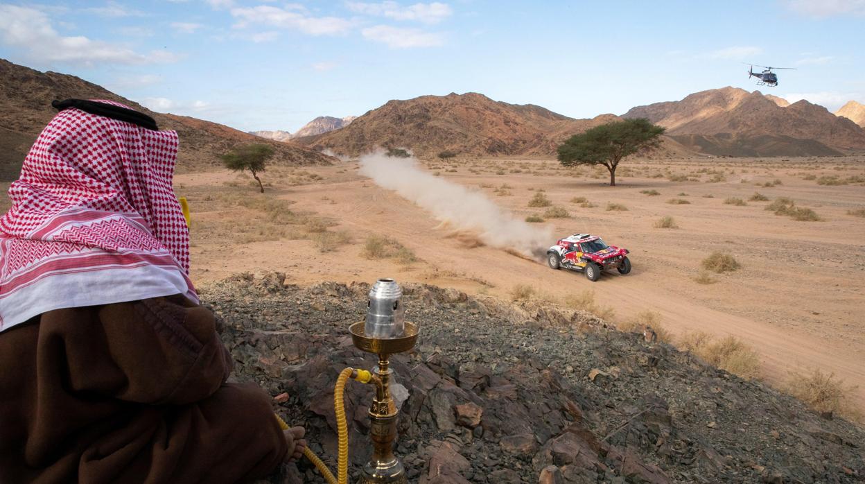 Un hombre saudí observa el coche de Sainz durante la cuarta etapa del Dakar