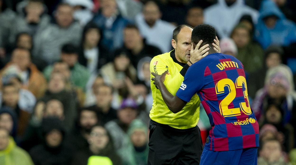 Samuel Umtiti y Mateu Lahoz durante un partido