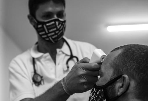 El jefe médico toma la temperatura a uno de los participantes en el evento