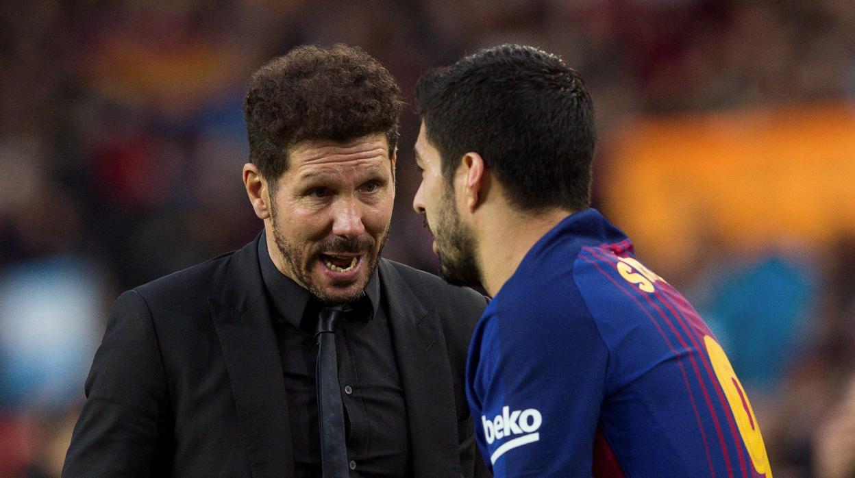 Simeone y Suárez se saludan durante un partido entre el Barcelona y el Atlético