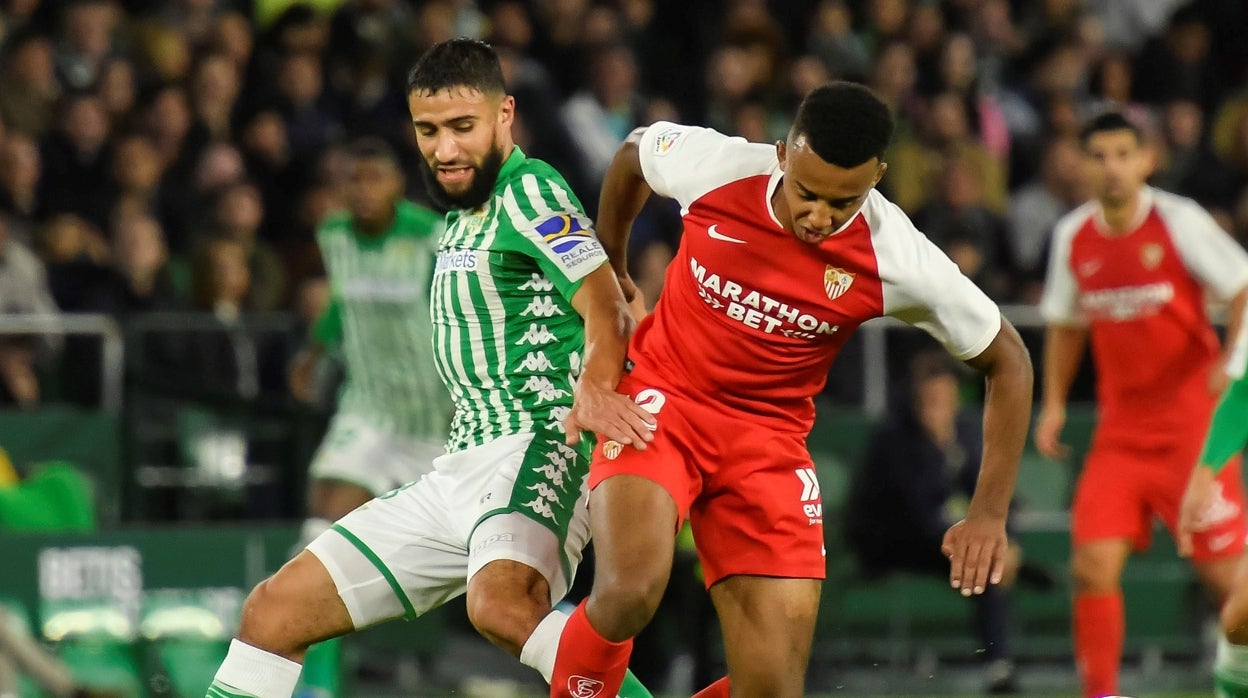 Fekir y Koundé pugnan por un balón durante el derbi de la 2019-20