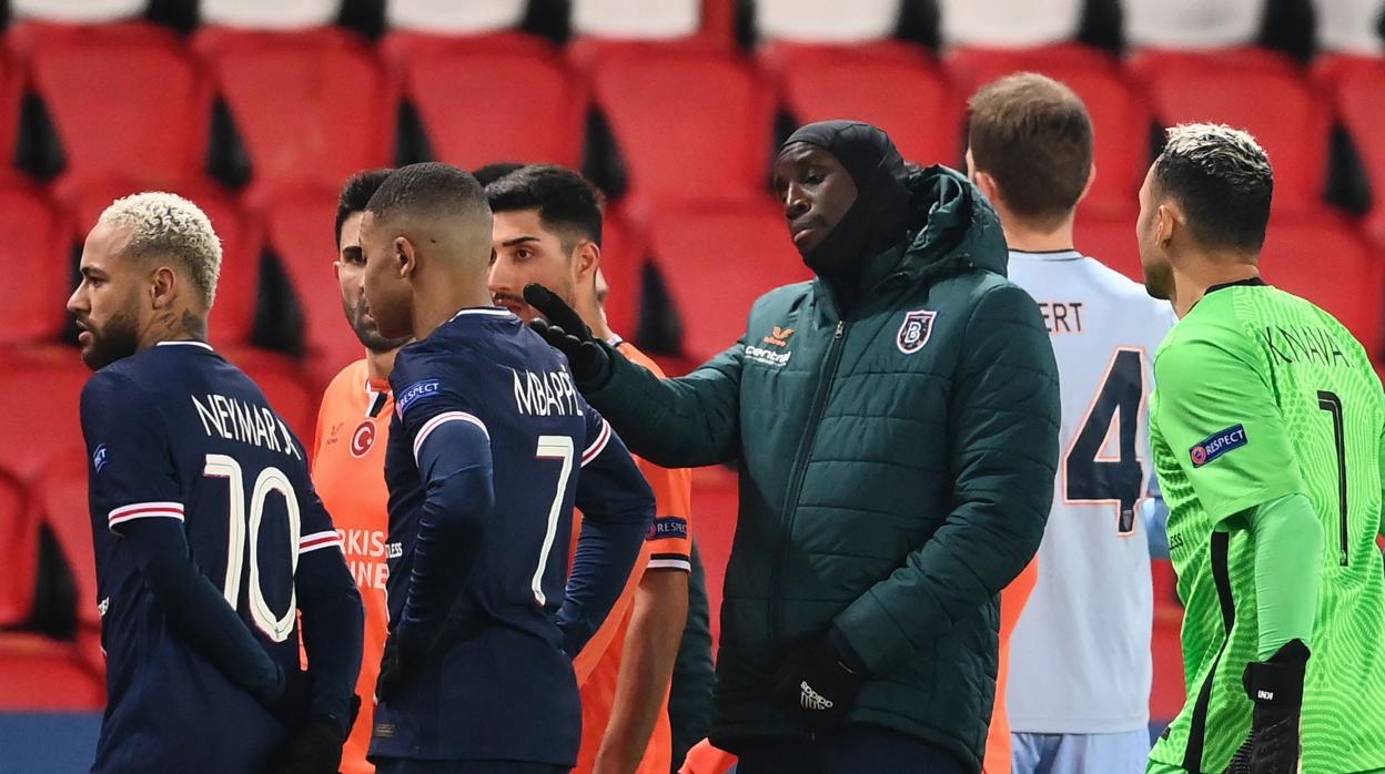 Jugadores del PSG y del Basaksehir dialogan antes de abandonar el campo