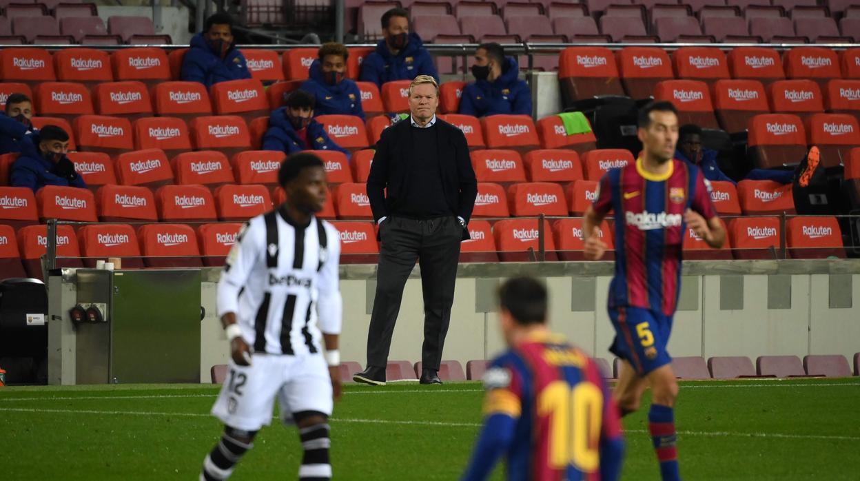 Ronald Koeman observa desde la banda cómo Messi intenta una jugada