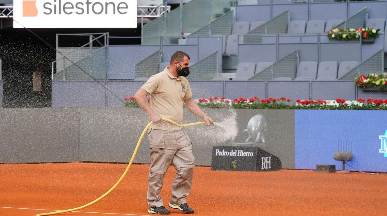 Un operario acondiciona la pista central del Mutua Madrid Open