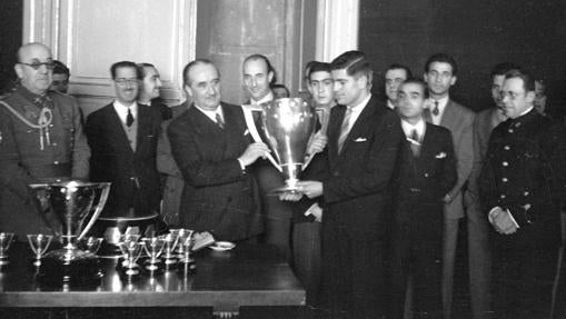 Alberto Alcacer, alcalde de Madrid, entrega la copa de campeón a los jugadores del Atlético