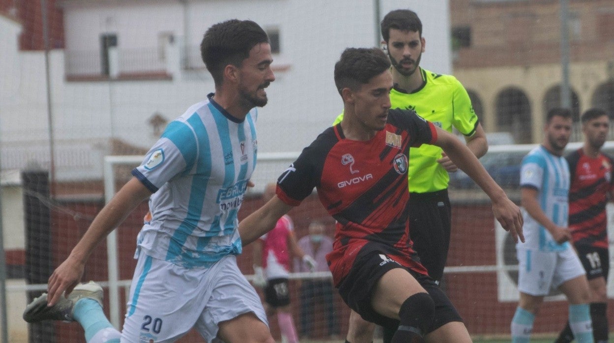 Sedeño y Migue Fernández disputan un balón ante la mirada del árbitro