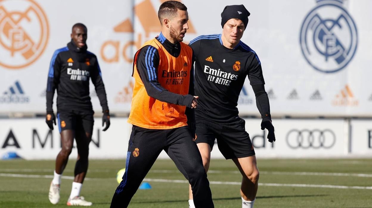 Hazard, junto a Kroos, en el entrenamiento de ayer en Valdebebas; Mendy observa en la lejanía