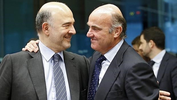 El comisario europeo de Asuntos Económicos, Pierre Moscovici,, conversa con el ministro español en funciones de Economía, Luis de Guindos