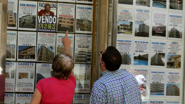 Dos personas buscando piso en una inmobiliaria de Zaragoza