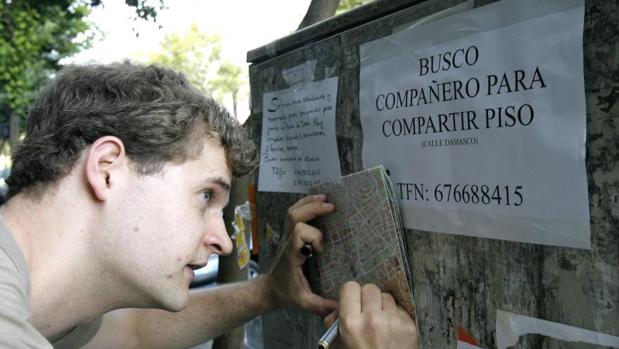 Estudiantes mirando carteles de alquiler en Córdoba