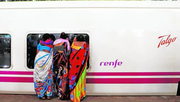 Tres mujeres indias observan el interior del vagón de un tren Talgo que cubre servicio en aquel país