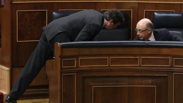 El ministro de Hacienda, Cristóbal Montoro (d), conversa con el portavoz del PP en el Congreso, Rafael Hernando