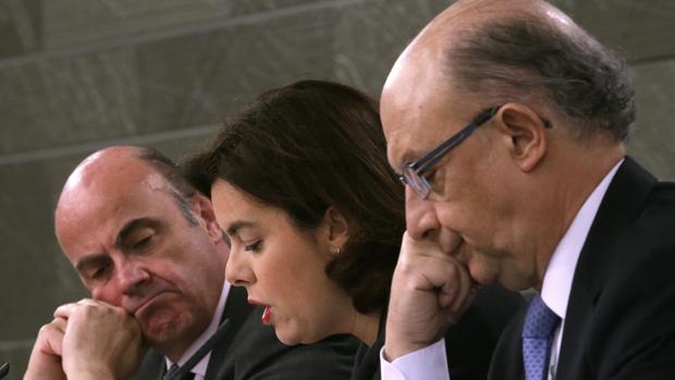 El ministro de Economía, Luis de Guindos, la vicepresidenta del Gobierno, Soraya Sáenz de Santamaría, y el ministro de Hacienda, Cristóbal Montoro