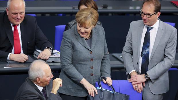 La canciller alemana, Angela Merkel (c), conversa con su ministro de Finanzas, Wolfgang Schäuble (i); y de Transporte, Alexander Dobrindt