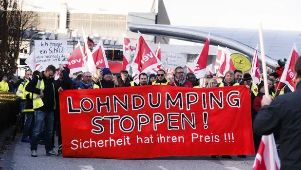 Empleados de la aerolínea alemana Lufthansa sostienen una pancarta en la que se puede leer '¡Parad la liquidación de los salarios! la seguridad tiene su precio' durante una manifestación
