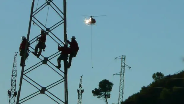 Trabajadores de Iberdrola subidos a una torre de electricidad de la compañía