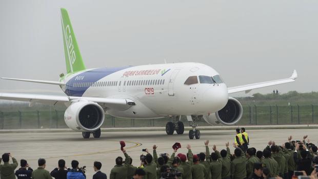 Miembros de la tripulación son recibidos por el personal del aeropuerto tras el aterrizaje del primer vuelo del avión comercial Comac C919 en el aeropuerto internacional de Pudong, Shanghai