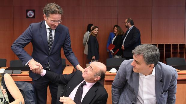 El presidente del Eurogrupo, Jeroen Dijsselbloem (izda), saluda al ministro de Economía Luis de Guindos
