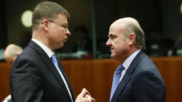 El vicepresidente de la CE para el Euro, Valdis Dombrovskis (i), y el ministro de Economía, Luis de Guindos