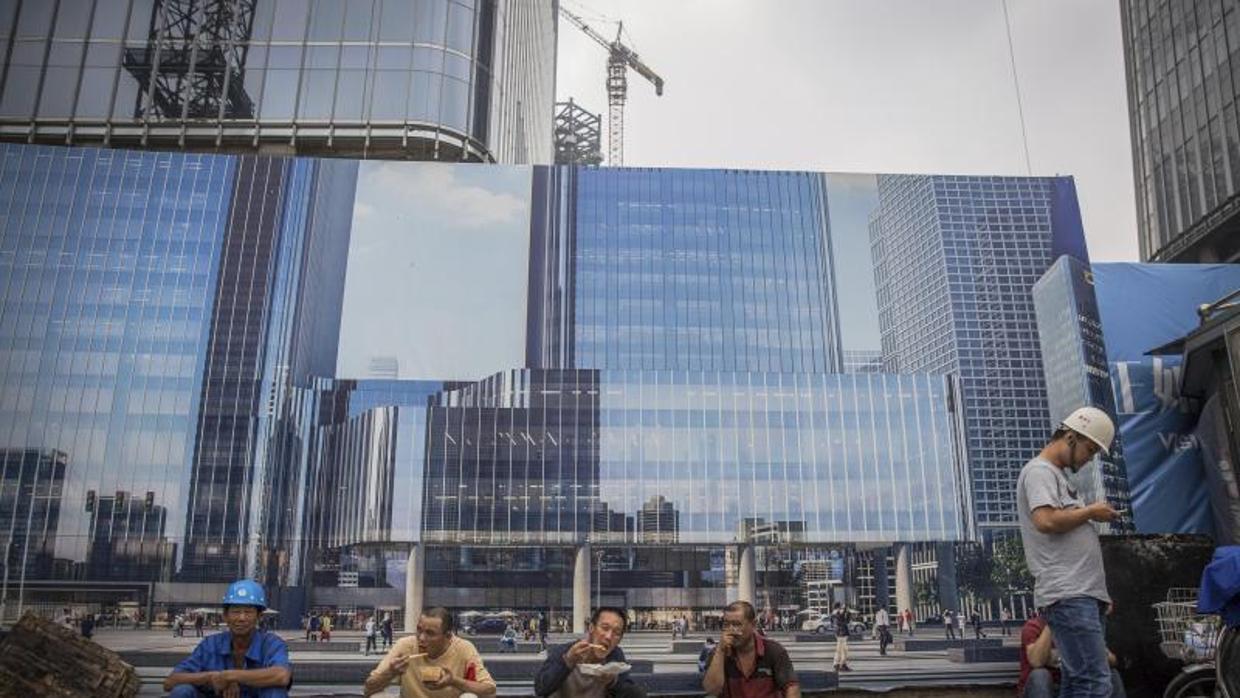 Obreros trabajando en edificios en construcción en el distrito financiero de Pekín (China)