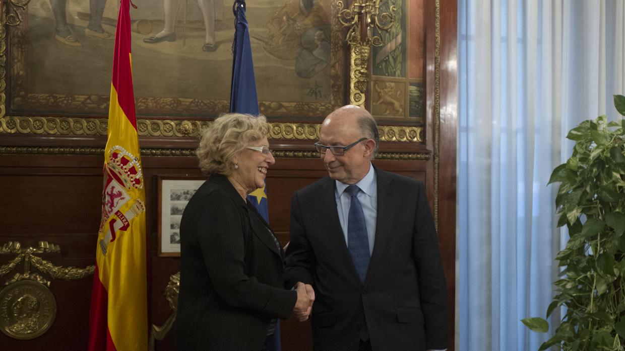 La alcaldesa de Madrid, Manuela Carmena, junto al ministro de Hacienda, Cristóbal Montoro