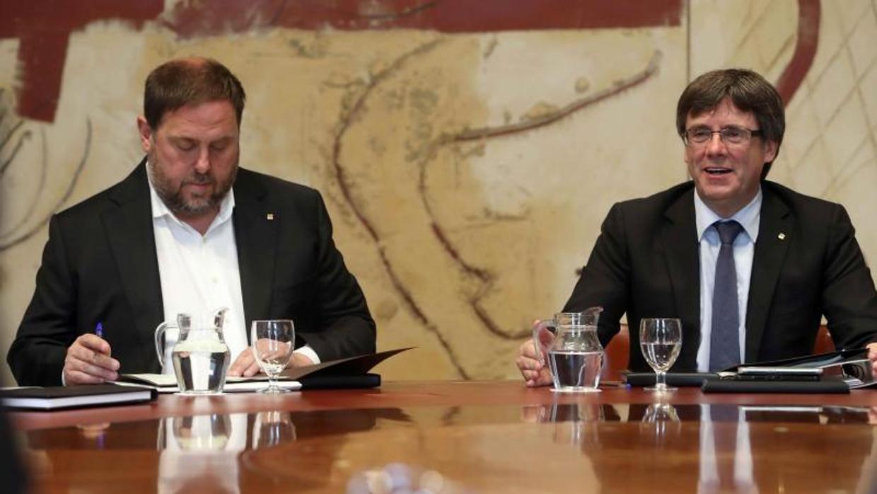 El presidente de la Generalitat, Carles Puigdemont (d), junto al vicepresidente, Oriol Junqueras (i)