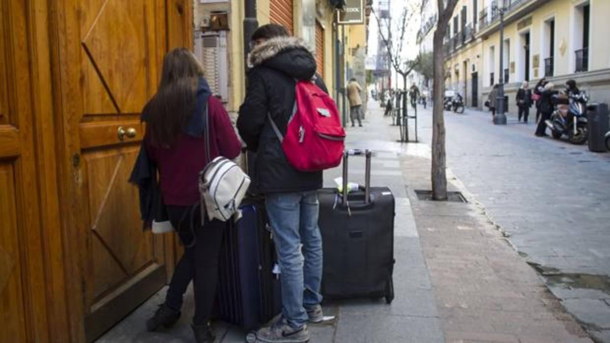 Jóvenes entrando a un piso turístico en el barrio de las Letras en Madrid