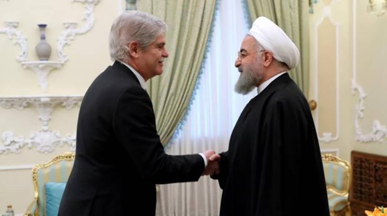 El exministro de Exteriores, Alfonso Dastis, junto al presidente iraní, Hasan Rohaní, en febrero pasado en Teherán