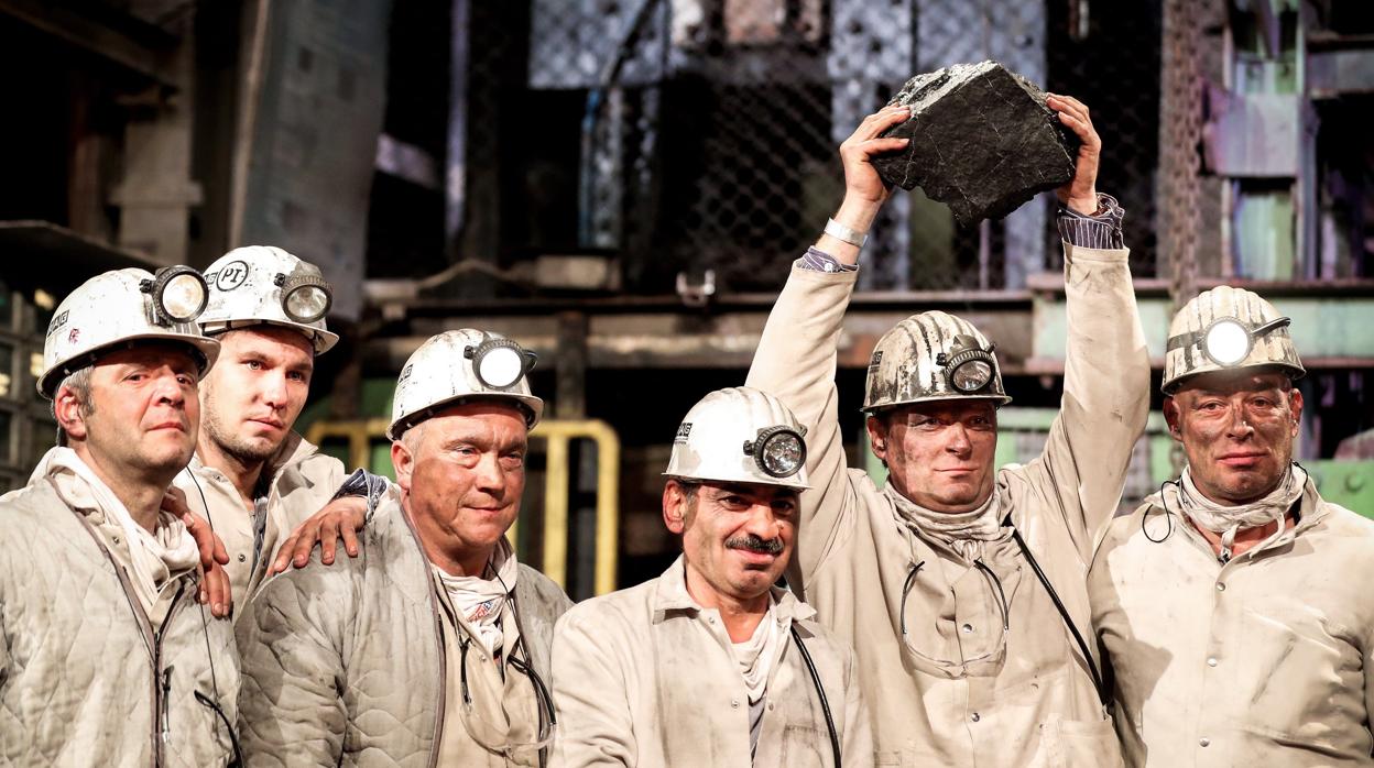 Varios mineros muestran el último trozo de carbón extraído ayer