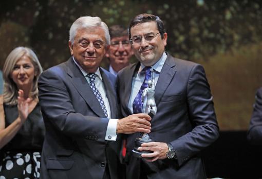 Juan José Porras Borrego, gerente de GRI Sevilla, a la derecha, recibe el premio de manos del presidente de la Cámara de Comercio, Francisco Herrero