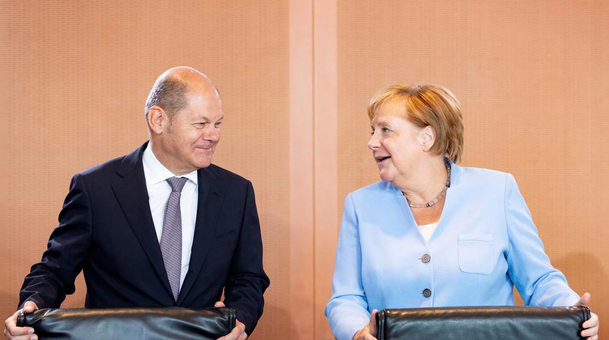 El ministro de Finanzas alemán, el socialdemócrata Olaf Scholz (izda) junto a la canciller alemana, Angela Merkel (dcha)