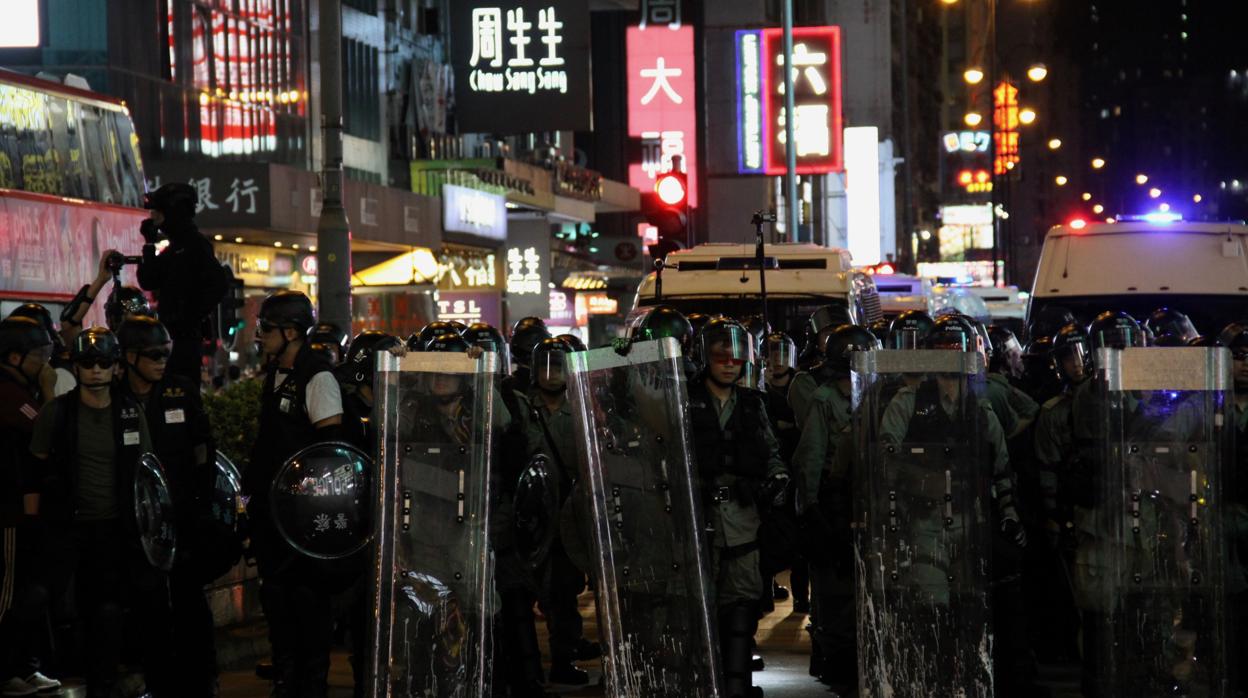 La Policía antidisturbios hace guardia en una calle comercial de Kowloon tras dispersar una protesta