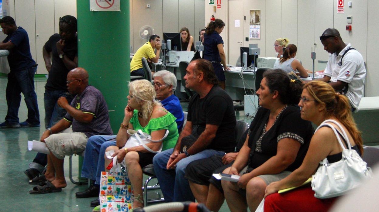 Un grupo de desempleados esperando en una oficina de empleo en Alicante