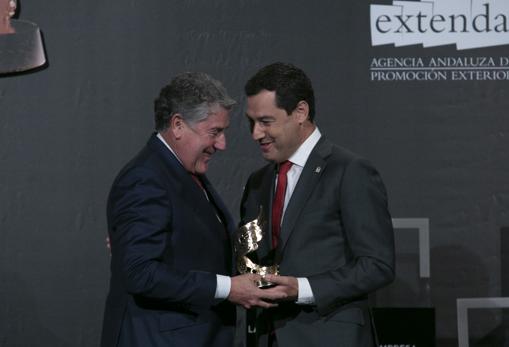 Miguel Gallego, presidente de Grupo Migasa, recoge el Premio de la mano de Juanma Moreno