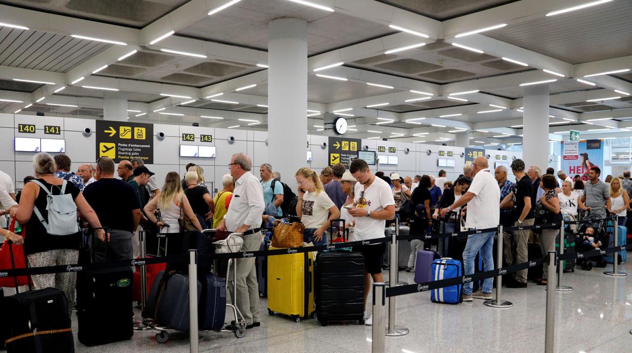 Varios turistas esperan para poder embarcar en sus vuelos, este martes, en el aeropuerto de Palma de Mallorca